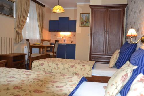 a hotel room with two beds and a kitchen at Penzion Aurooms in Zlatníky