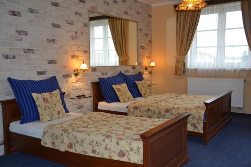 a hotel room with two beds and a chair at Penzion Aurooms in Zlatníky