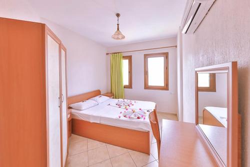 1 dormitorio con cama, mesa y ventana en Minta Apartments, en Dalyan