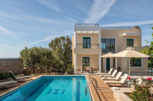 a villa with a swimming pool and a house at Aris Villa in Panormos Rethymno