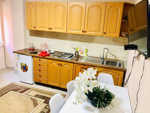 a kitchen with wooden cabinets and a table with flowers on it at Tirana Central Apartment - Spacious 2 Bedroom in Tirana