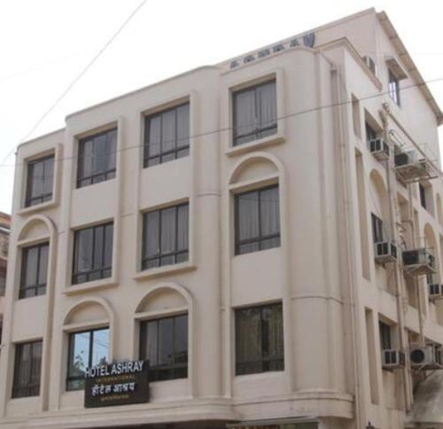 a large white building with a sign on it at Hotel Ashray International, Sion - Near BKC in Mumbai