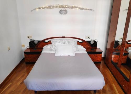 1 cama con sábanas blancas y almohadas en una habitación en El piso perfecto para disfrutar de Zamora, en Zamora