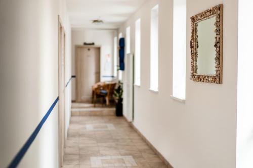 a hallway with white walls and a mirror on the wall at Penzion Labska Marina in Poděbrady