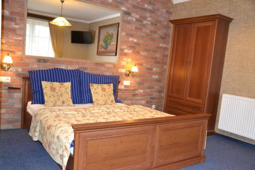 a bedroom with a bed and a brick wall at Penzion Aurooms in Zlatníky