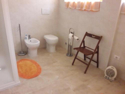 ein Bad mit einem WC und einem Stuhl darin in der Unterkunft BED Magnolie in Lainate