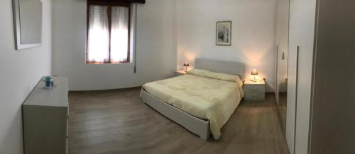 um quarto branco com uma cama e uma janela em Multi Vacanza La Ciaccia em Valledoria