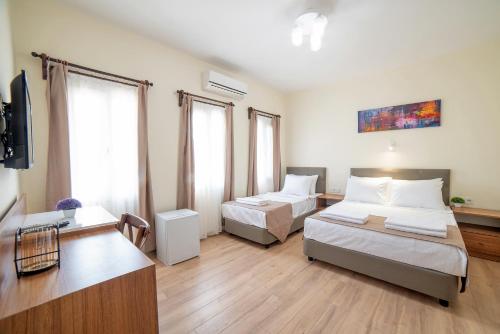 um quarto de hotel com duas camas e uma televisão em 9Bodrum Hotel em Turgutreis