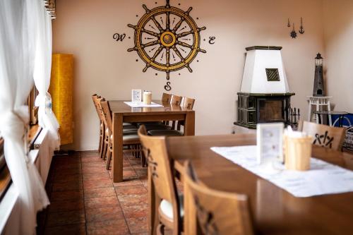 a dining room with a table and a clock on the wall at Penzion Labska Marina in Poděbrady