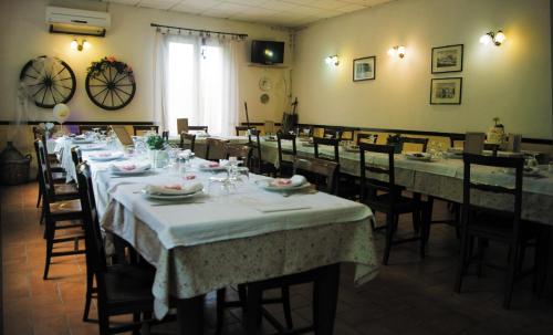 un comedor con mesas y sillas con manteles blancos en Agriturismo Boschi, en Reggiolo