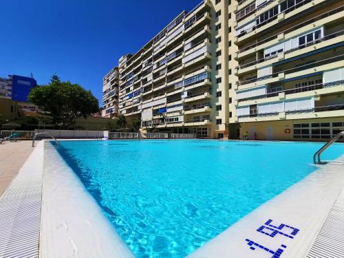 an empty swimming pool in front of a building at Apartamento Carihuela Torremolinos in Torremolinos