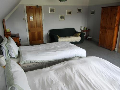 a bedroom with two beds and a couch at The Old Post House in Moretonhampstead
