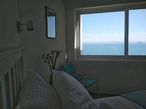 a bedroom with a bed and a view of the ocean at Luxury Penthouse 1BR-Seafront-Seasonal Pool-Central in Larnaka