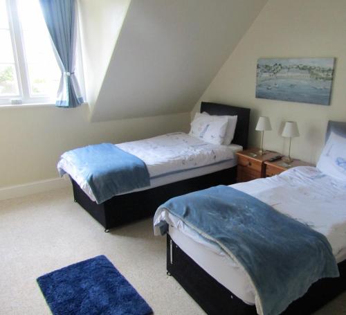 a bedroom with two beds and a window at The Old Post House in Moretonhampstead