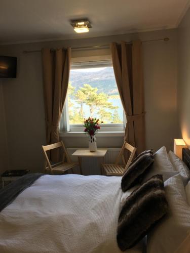 a bedroom with a bed with a window and a table at Lochalsh View, Kyle, 1 Mile to Skye in Kyle of Lochalsh