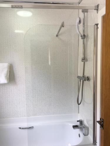 a glass shower door in a bathroom with a sink at Lochalsh View, Kyle, 1 Mile to Skye in Kyle of Lochalsh