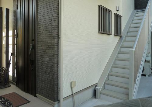 a staircase in a house with a brick wall at Kanaloa Funabashi in Funabashi