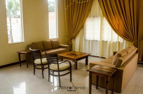 a living room with a couch and chairs and a table at Hotel Guararapes in Miguel Pereira