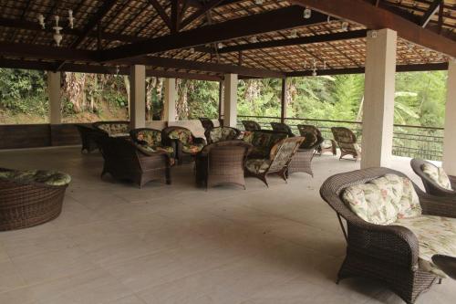 a group of chairs and tables on a patio at Hotel Guararapes in Miguel Pereira
