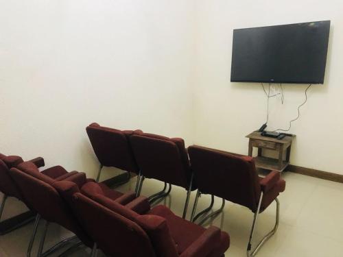 a room with chairs and a flat screen tv at Hotel Guararapes in Miguel Pereira