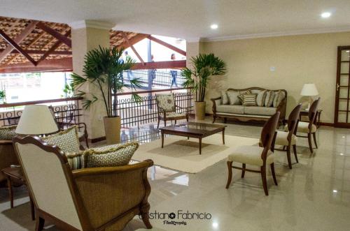 a living room with chairs and a couch and a table at Hotel Guararapes in Miguel Pereira