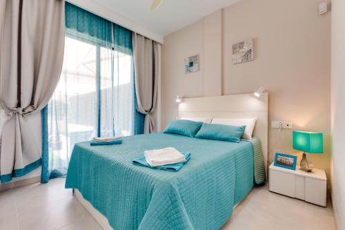プレヤス・デ・オリフエラにあるFamily house in La Zeniaのベッドルーム(青いベッド1台、大きな窓付)