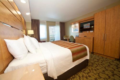a hotel room with a bed and a flat screen tv at DeSoto Beach Hotel in Tybee Island
