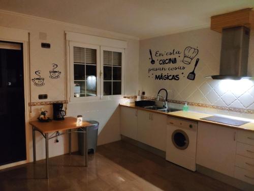 een keuken met een wastafel en een wasmachine bij Villa CiTe- jardines/BBQ/terrazas/ para familias in Teruel
