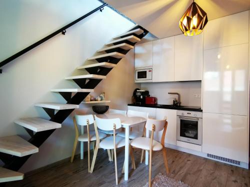 eine Küche mit einem Esstisch und einer Treppe in der Unterkunft Kuninga 24 Apartment in Pärnu