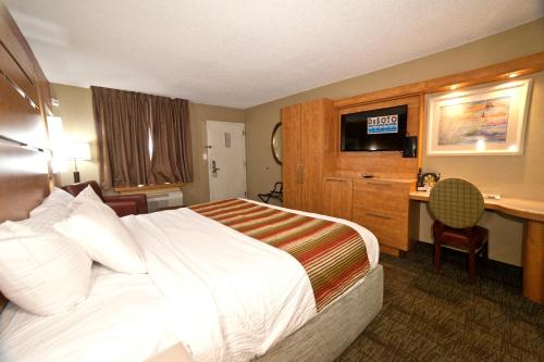 a hotel room with a bed and a television at DeSoto Beach Hotel in Tybee Island