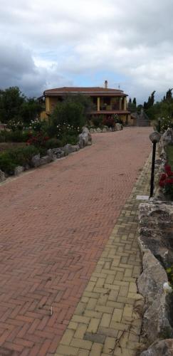 a brick road with a house in the background at Villa Sorrentina in Alghero