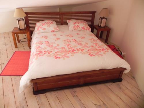 La Bastide des Vasses "Le Loft" في كوكورون: غرفة نوم بها سرير كبير وعليه زهور