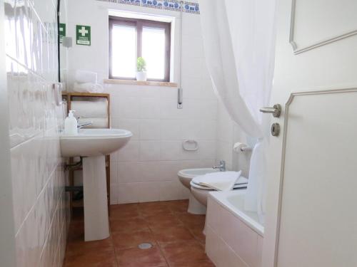 a white bathroom with a sink and a toilet at IM On Luz Arte in Luz