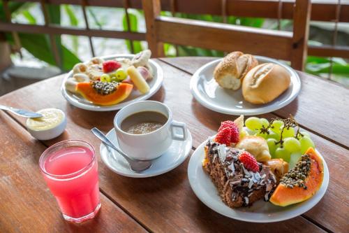 - une table avec des assiettes de nourriture et une tasse de café dans l'établissement Chauã Porto Hotel, à Porto Seguro