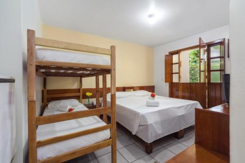 a bedroom with two bunk beds and a table at Chauã Porto Hotel in Porto Seguro