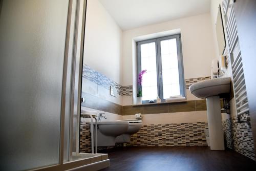 uma casa de banho com um lavatório, um WC e uma janela. em Nuovo Albergo Operai em Monfalcone
