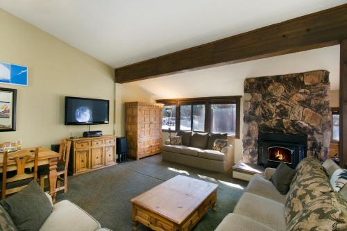 a living room with a couch and a fireplace at Mammoth Village Properties by 101 Great Escapes in Mammoth Lakes