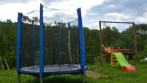 a blue trampoline in a field with a playground at Casa Papițu in Vadu Izei