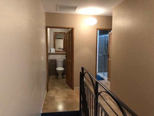 a hallway with a bathroom with a toilet and a staircase at ARCHE DE PEZENAS in Pézenas