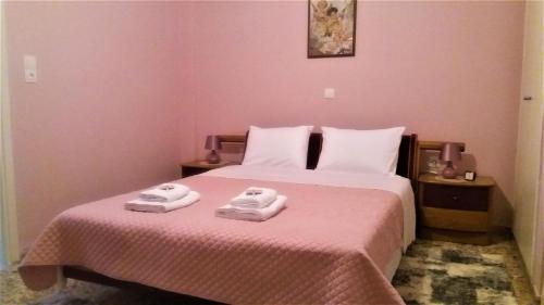 a bedroom with a bed with two towels on it at Crystal Home near Airport in Artemida