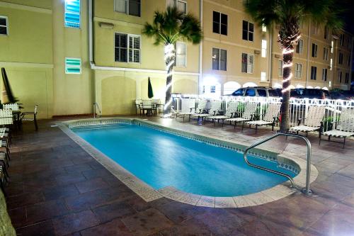 a swimming pool in a hotel with tables and chairs at DeSoto Beach Hotel in Tybee Island