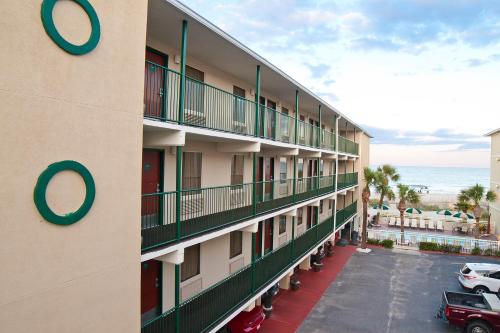 a building with a parking lot next to the ocean at DeSoto Beach Hotel in Tybee Island