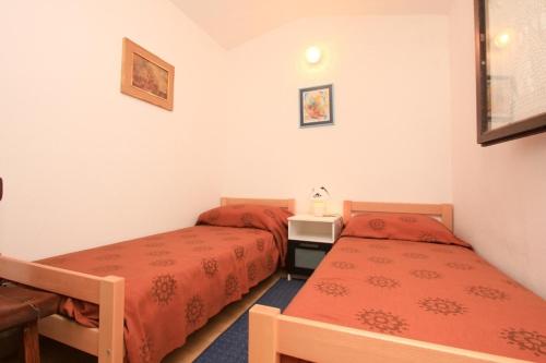 two beds in a room with red sheets at Apartment Lavender in Selca kod Bogomolja