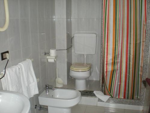 a bathroom with a toilet and a sink and a shower at Aer Hotel Malpensa in Oleggio