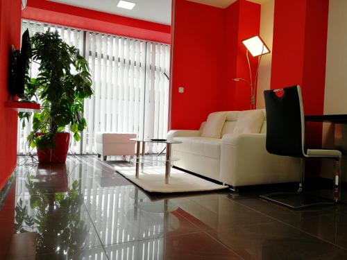 a living room with a white couch and red walls at Apartmány Duo in Dačice