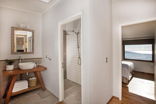 bagno bianco con lavandino e doccia di Cala Melí a Puerto Varas