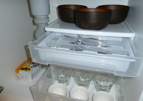 a refrigerator with glasses and bowls on top of it at Kanaloa Funabashi in Funabashi
