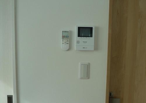 a microwave on a wall next to a door at Kanaloa Funabashi in Funabashi