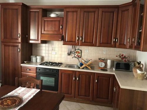 a kitchen with wooden cabinets and a stove top oven at La Gardenia in Ioppolo Giancaxio