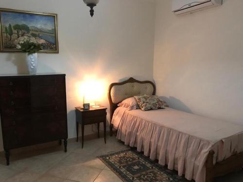 een slaapkamer met een bed en een tafel met een lamp bij La Gardenia in Ioppolo Giancaxio